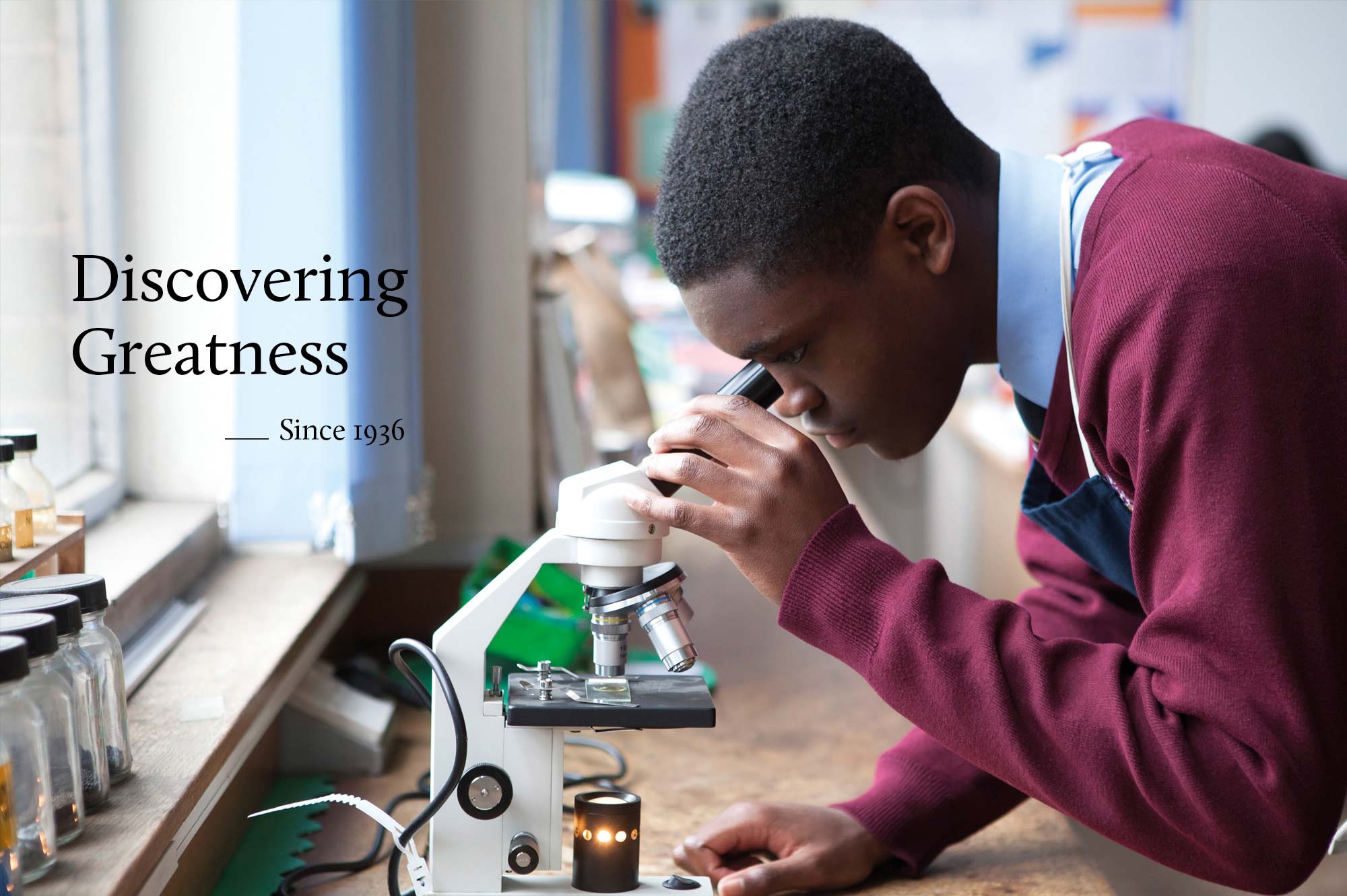 Priory School pupil looking through a microscope